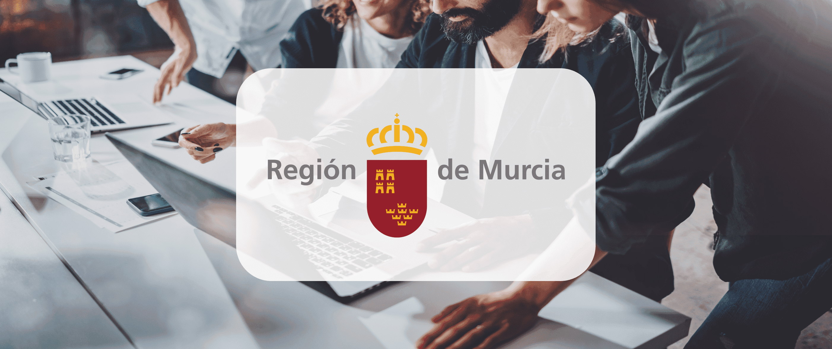 Gente mirando un ordenador con el logo de la region de Murcia encima